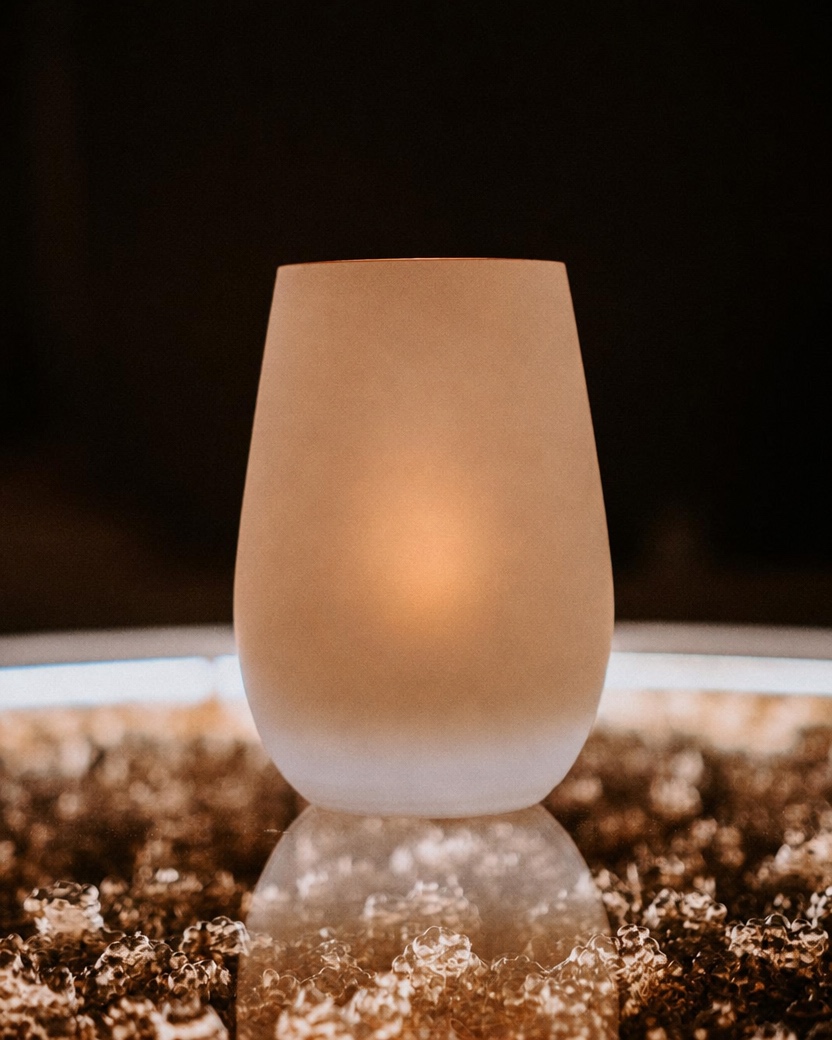 Teelichtglas in Weiß/Gold mit einem Beispiel-Emblem in Gold statt des Mondes, als Platzhalter für Ihr Logo