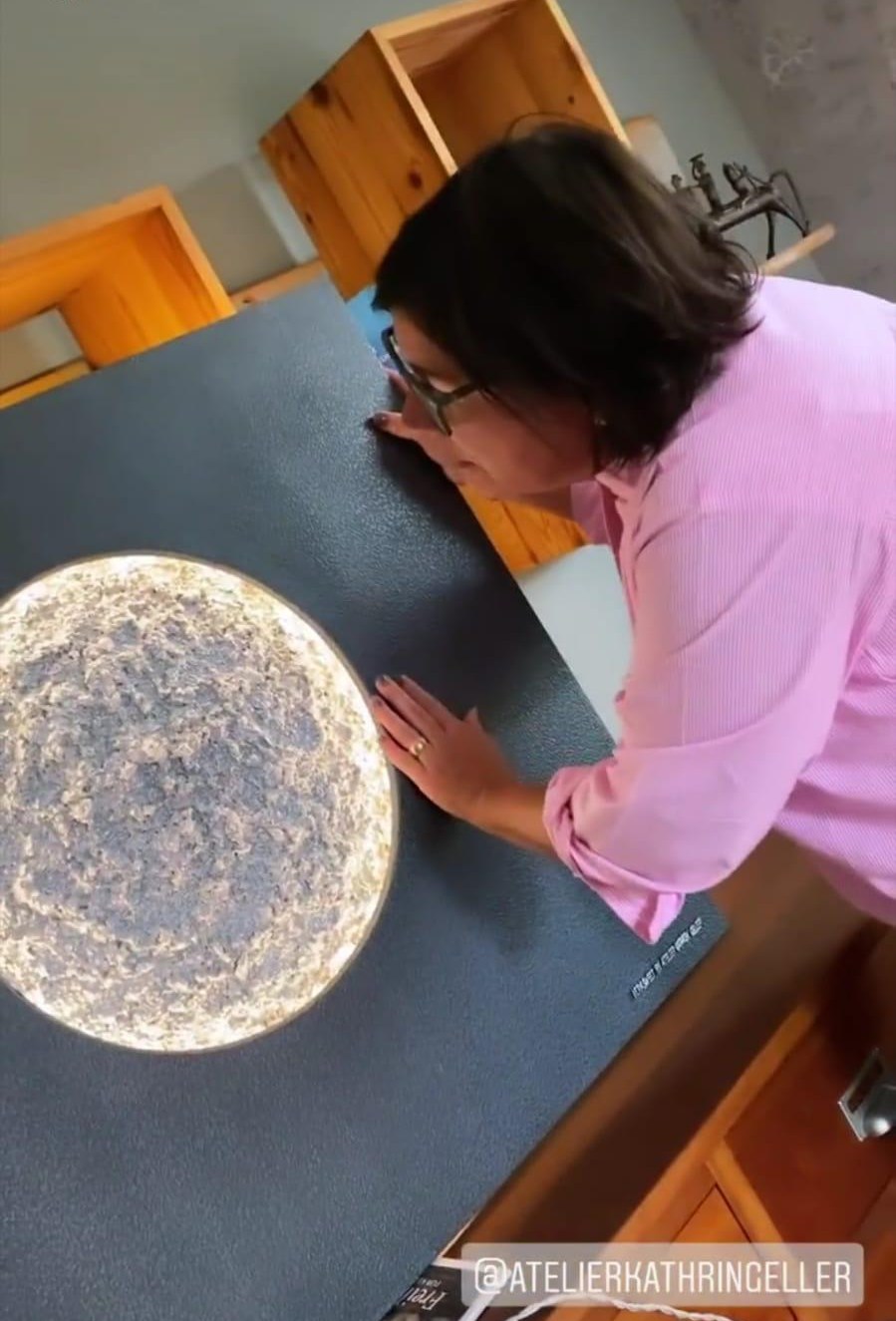 Vera Int-Veen beugt sich über ein Lichtkunstwerk mit Mond