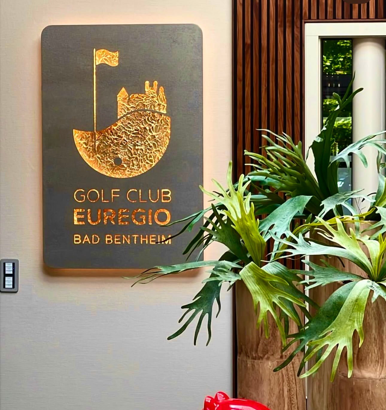 Logokunstwerk mit Logo Gold, abgerundete Ecken, beleuchtet, im Golfclub