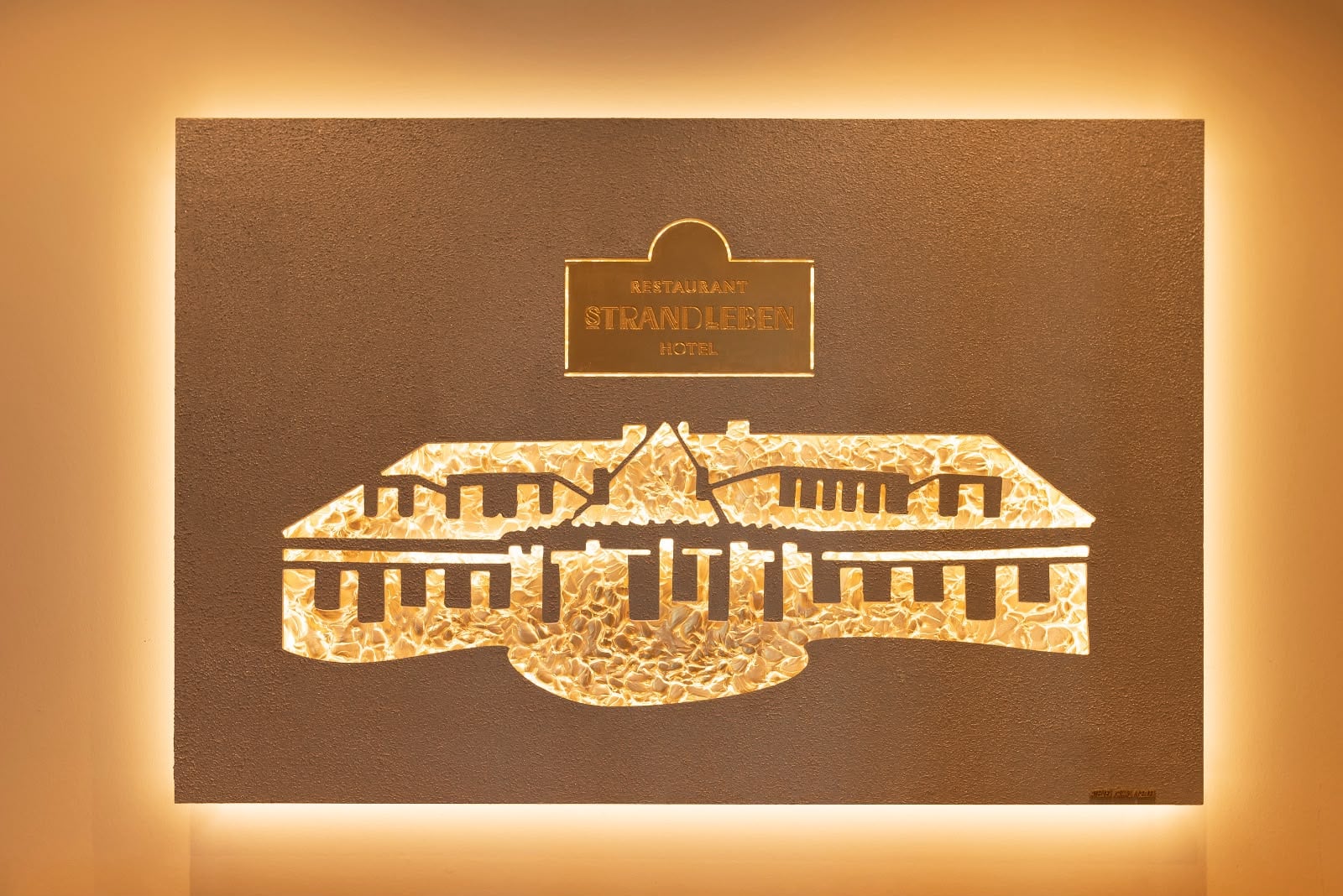 Logokunstwerk mit Logo Gold, beleuchtet, im Hotel